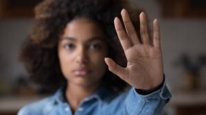 woman show palm hand opposes discrimination, make stop gesture