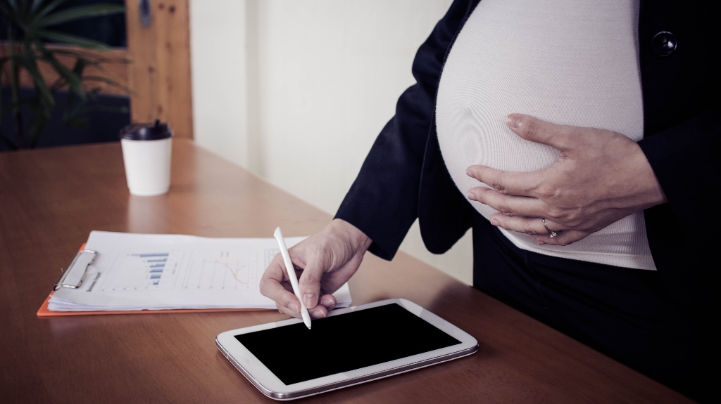 Pregnant woman working on tablet