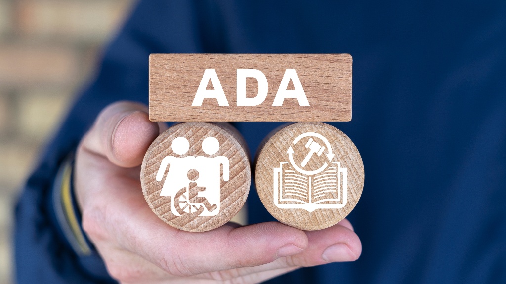 Man holding wooden blocks with icons and abbreviation: ADA