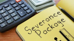 Calculator, stack of US dollar bills, and yellow notebook with "Severance Package" handwritten.